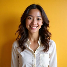 Professional headshot of a female nutritionist with a warm, engaging smile, dressed in a smart business casual top, against a bright and inviting background.